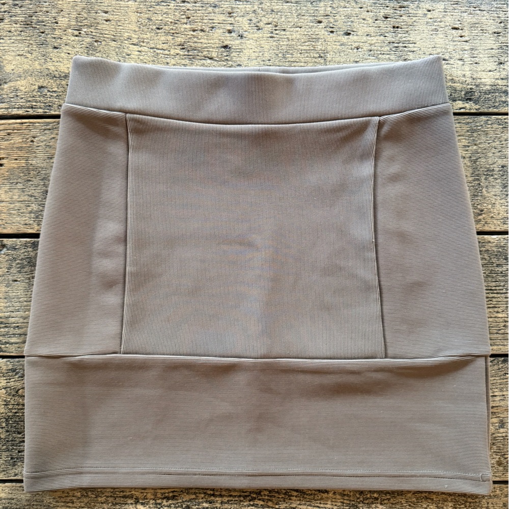 Thick ribbed knit bondage style mini skirt. Stylized seam details.